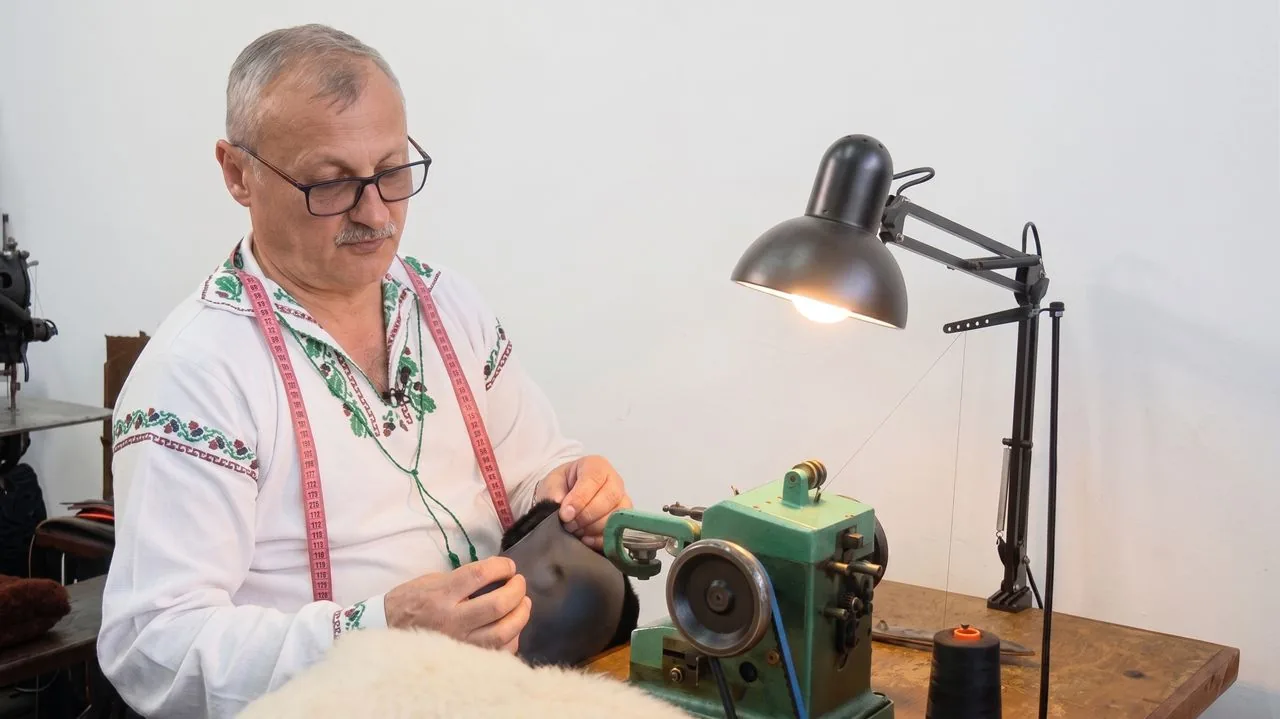 Florin Spiridon potrivind cusătura unui clin de căciulă, în atelier